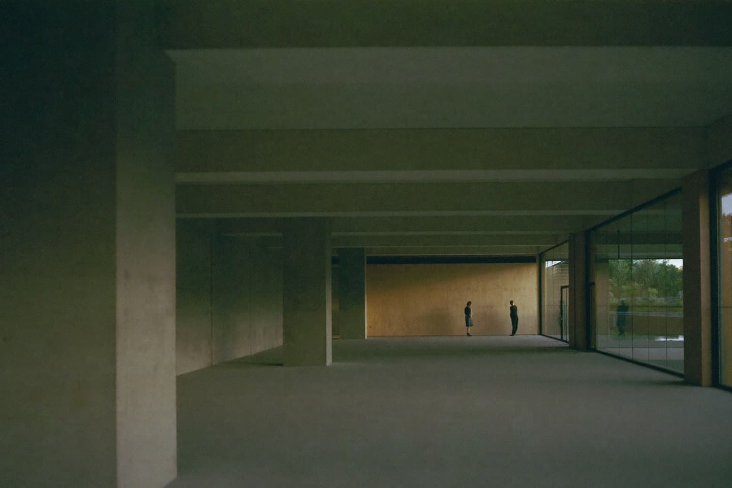 Two people standing in a concrete gallery